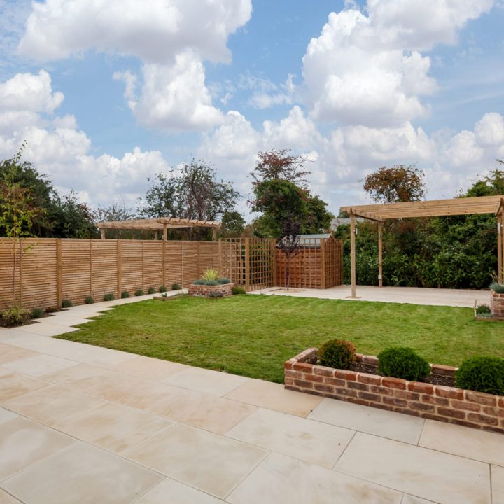 A warm decorative concrete backyard patio, adorned with a graceful pergola